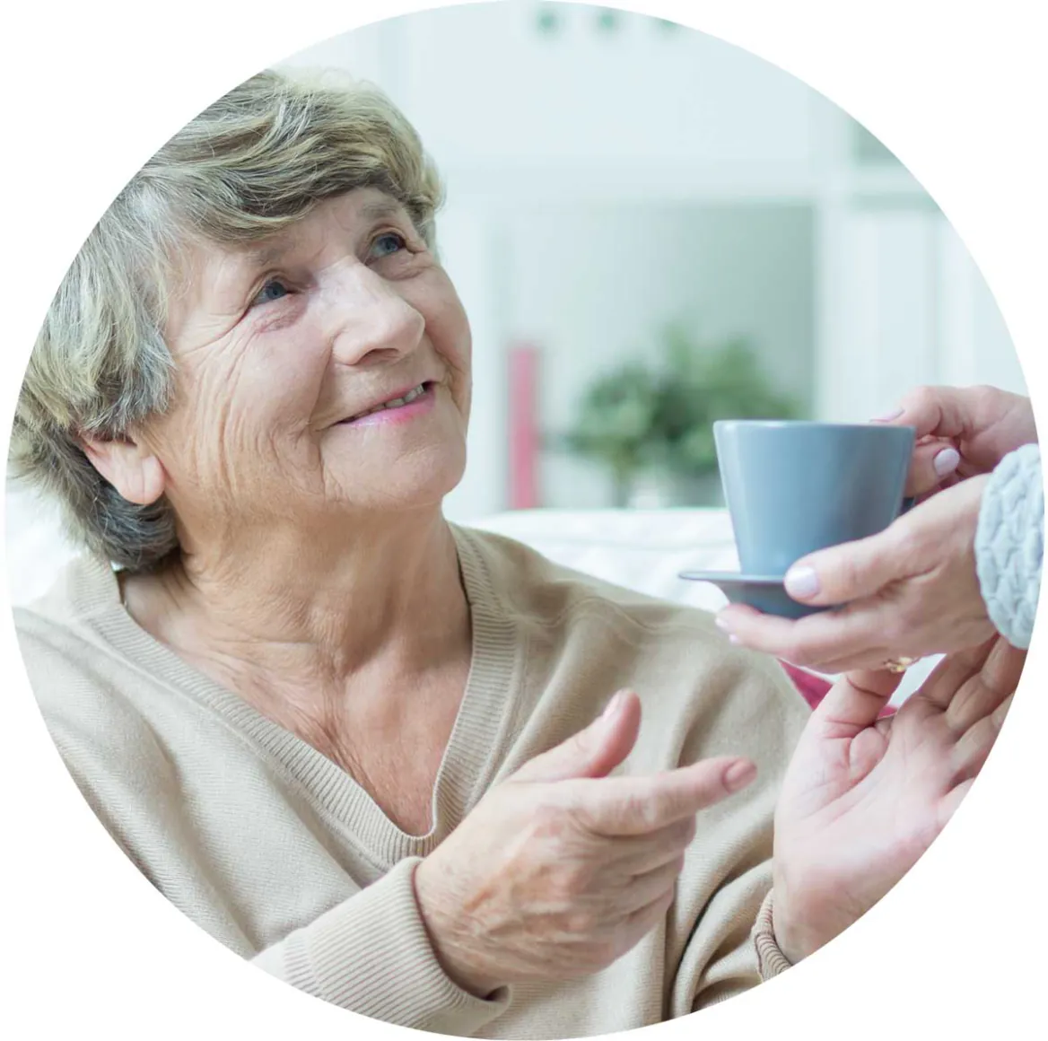 Smiling older woman being handed a cup