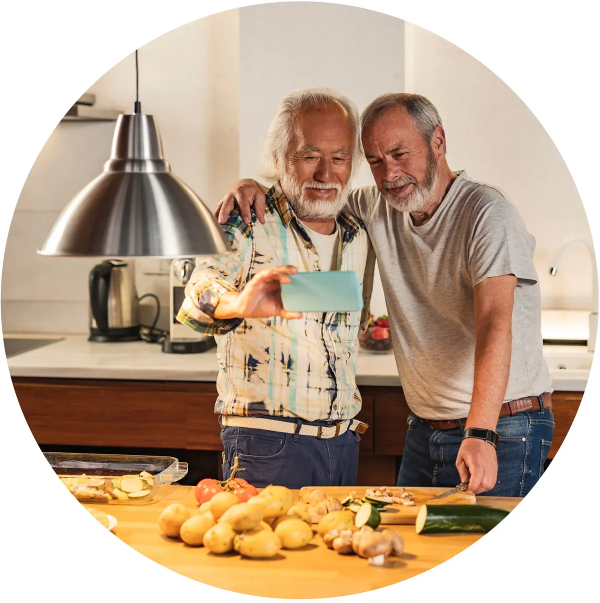 Older male couple taking a selfie together in a kitchen