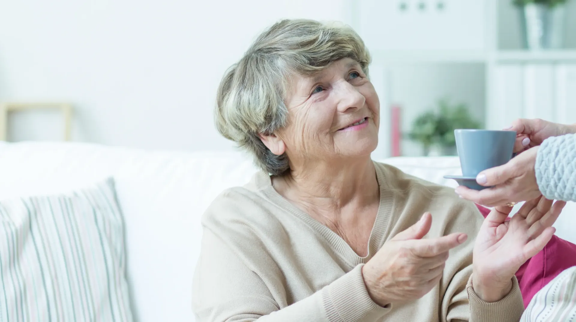 Smiling older woman being handed a cup